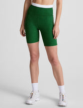 green high-waisted biker shorts with a 7" inseam, waistband colorblock panels, and contrast piping detail on leg.